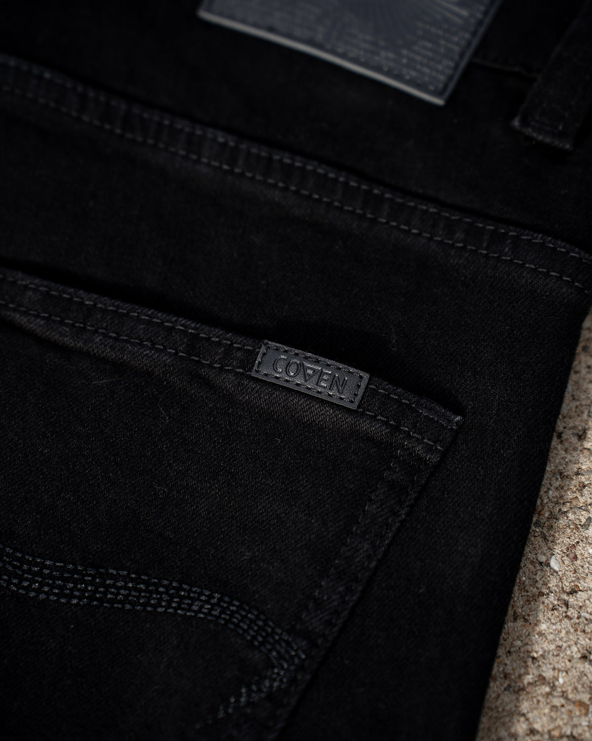 The Wormskin Jeans in Schwarz, Gesäßtasche im Detail mit eingenähtem COVEN Webetikett