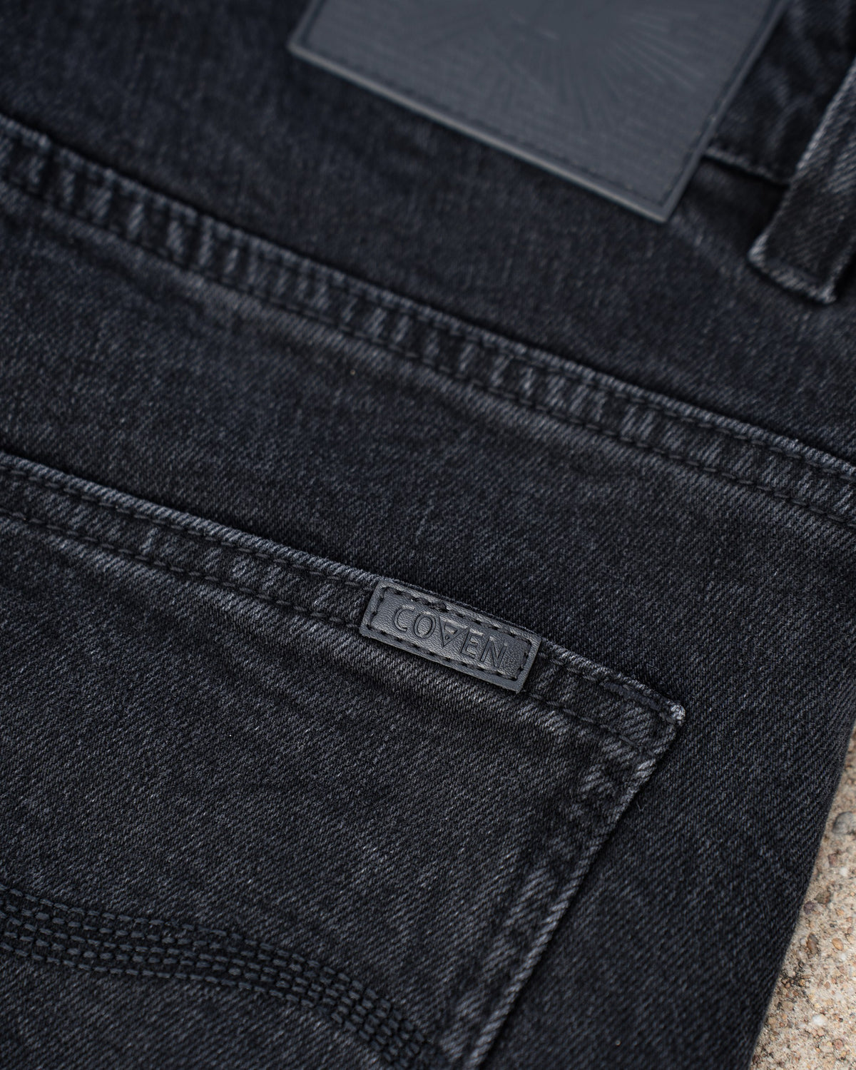 The Wormskin Jeans in Washed Black, Gesäßtasche im Detail mit eingenähtem COVEN Webetikett