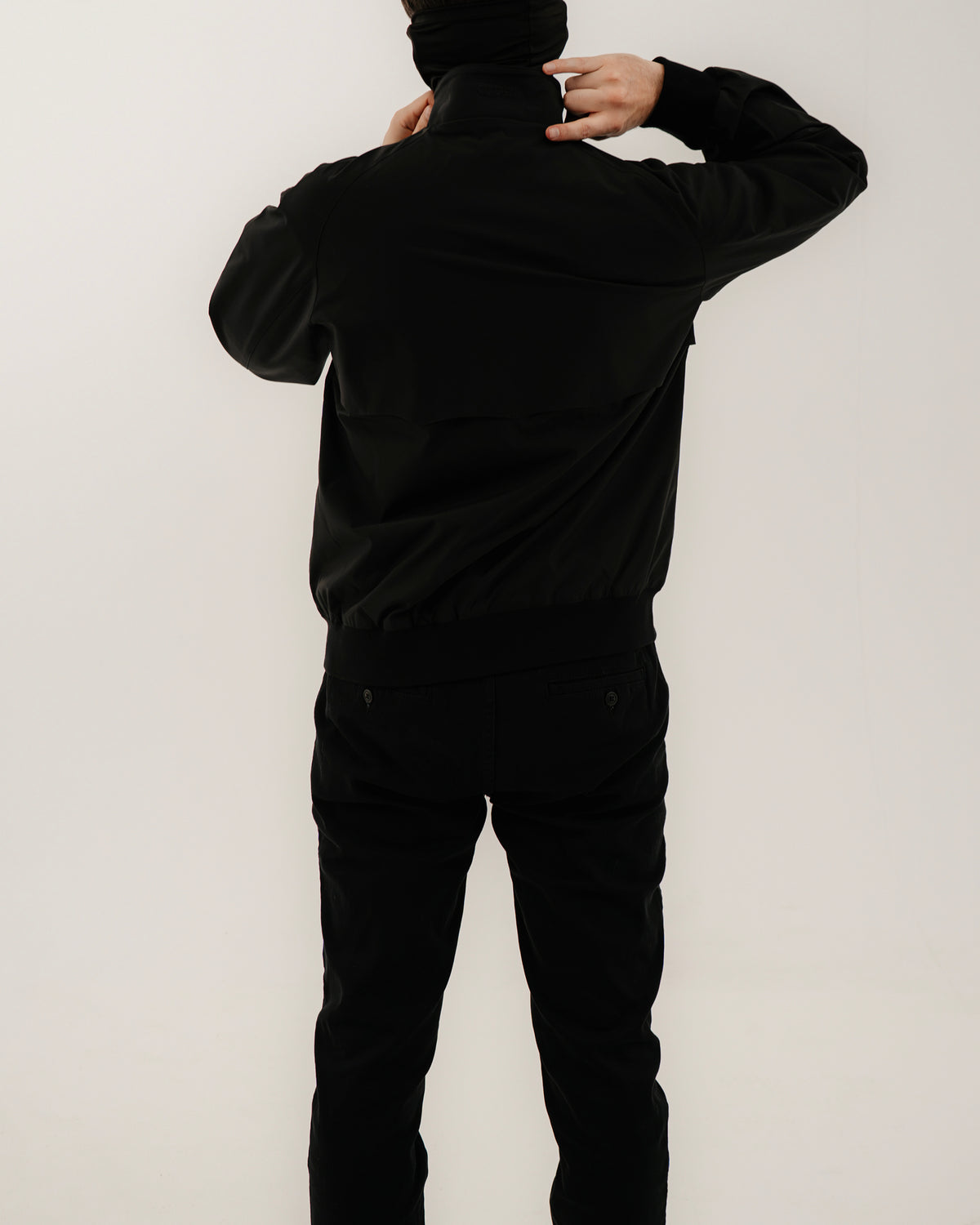The Pariah Harrington Jacke in Schwarz am Model, Rückansicht in voller Länge