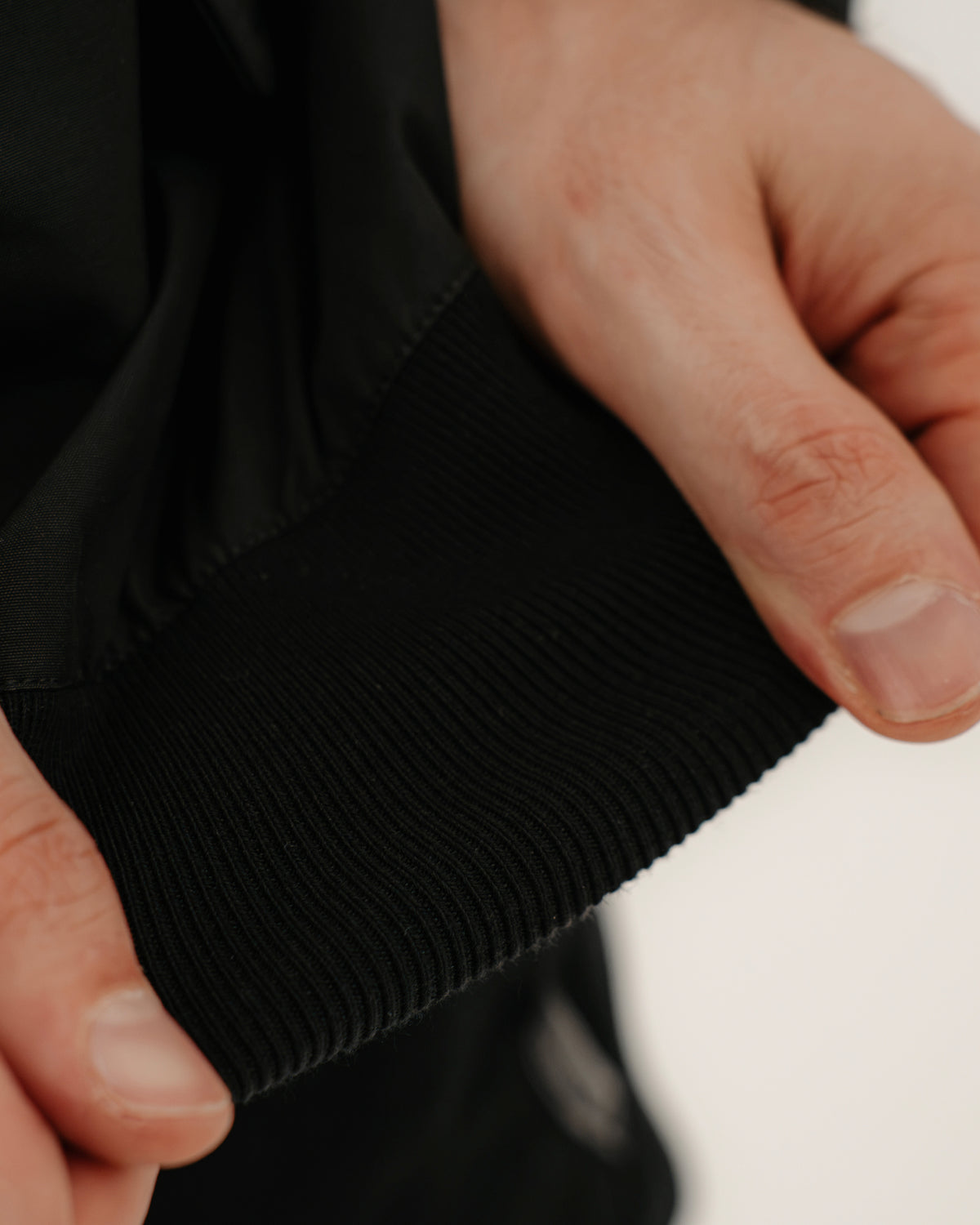 The Pariah Harrington Jacke in Schwarz am Model, flexibles Ärmelbündchen im Detail
