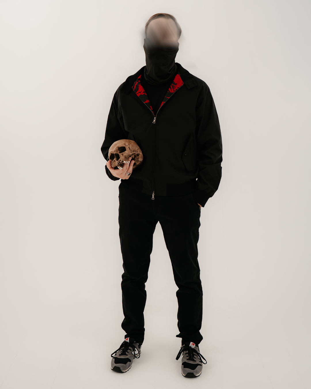 The Pariah Harrington Jacke in Schwarz am Model, Ganzkörperaufnahme mit Totenschädel und Tiger Stripe Red Futter am Kragen