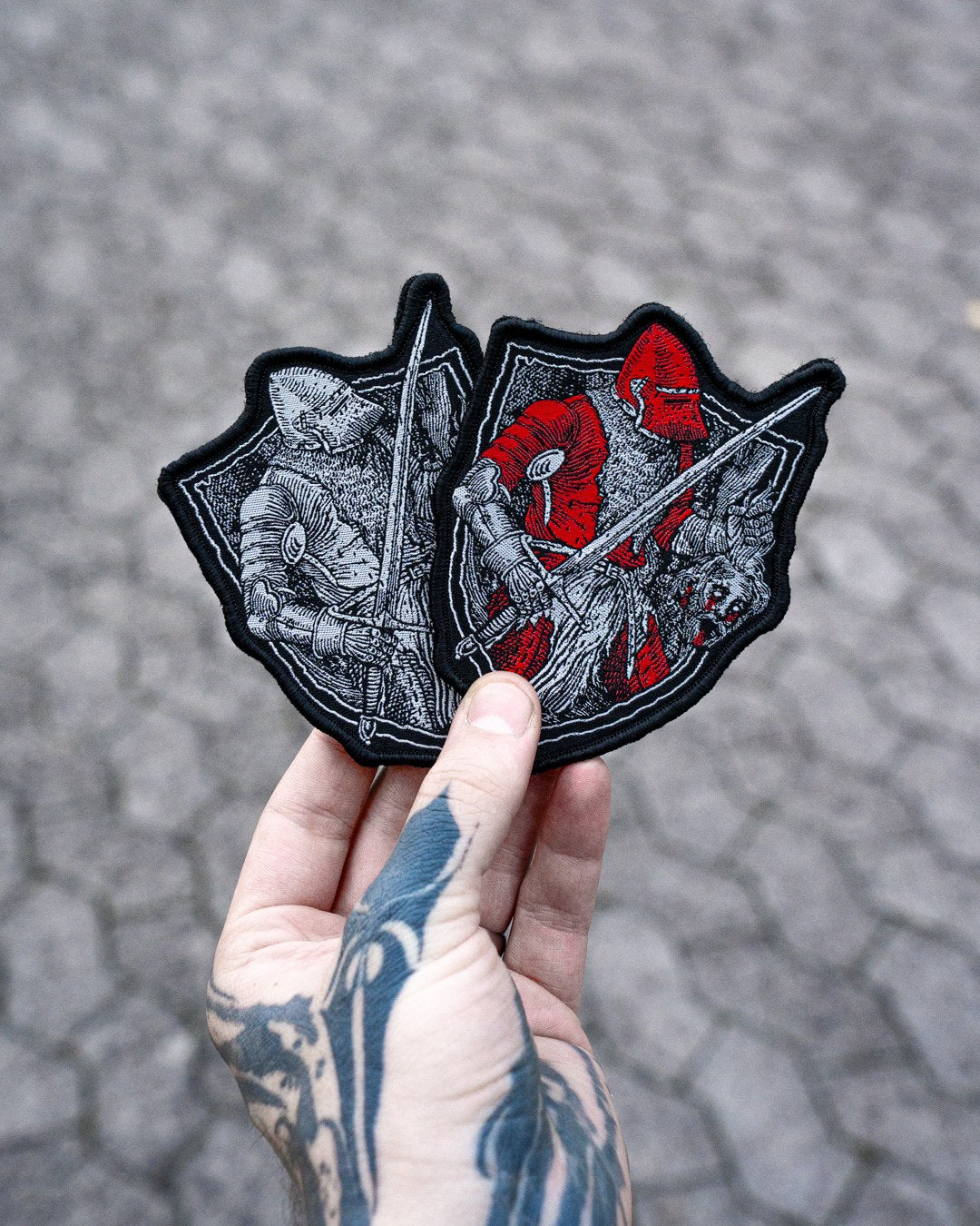 Blutzoll Patch, beide Editionen nebeneinander in der Hand gehalten