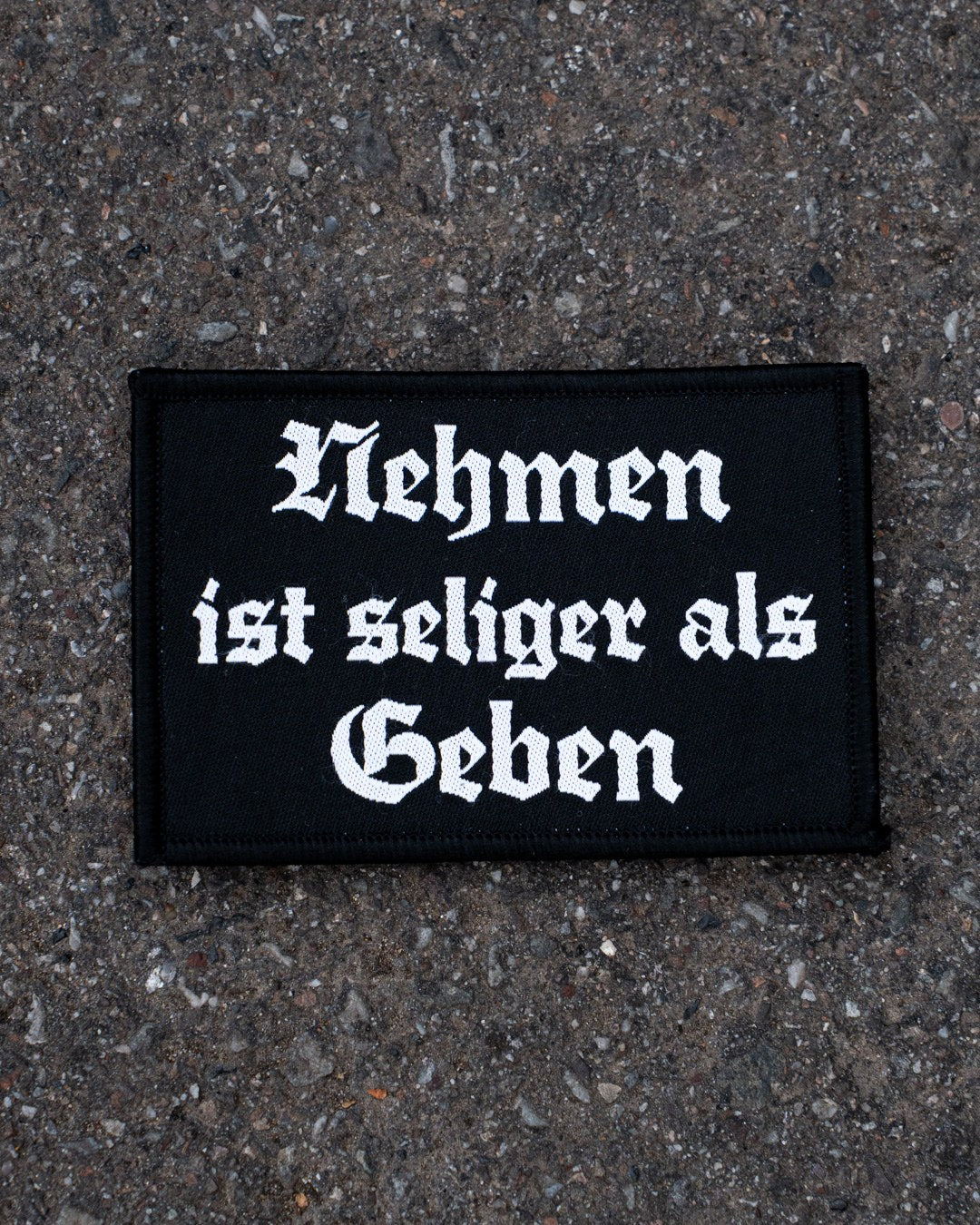 Nehmen ist seliger als Geben Patch von COVEN, Schriftzug in Frakturschrift