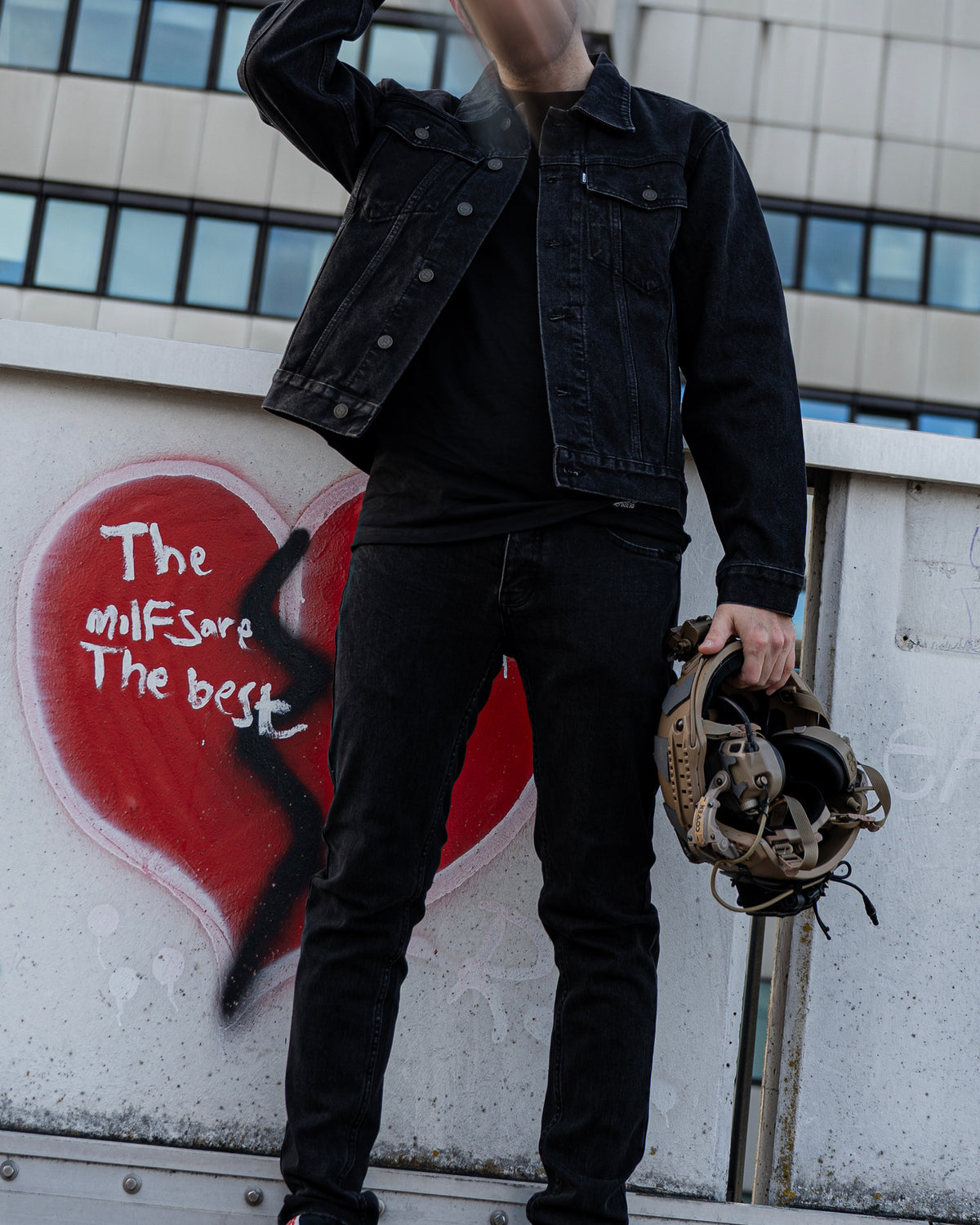 The Wormskin Jeans getragen zur Denim-Jacke, Ganzkörper mit Helm in der Hand