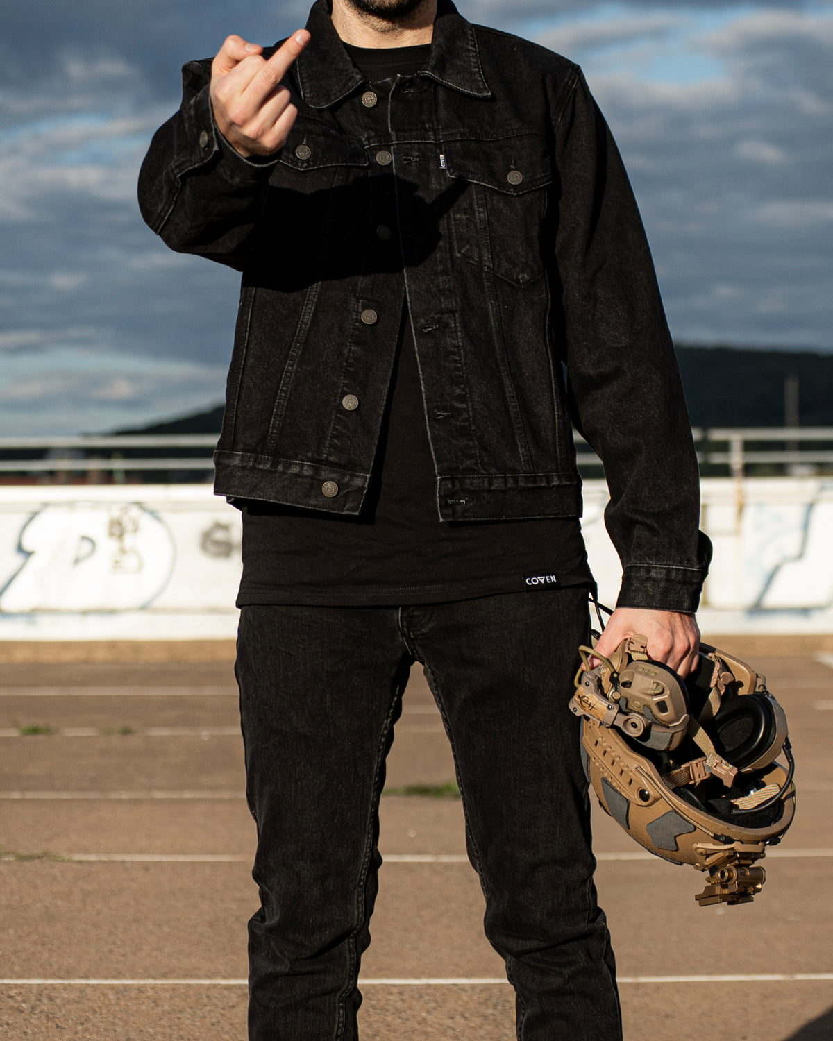 The Wormskin Jeans getragen zur Denim-Jacke, Hüftpartie mit Helm in der Hand