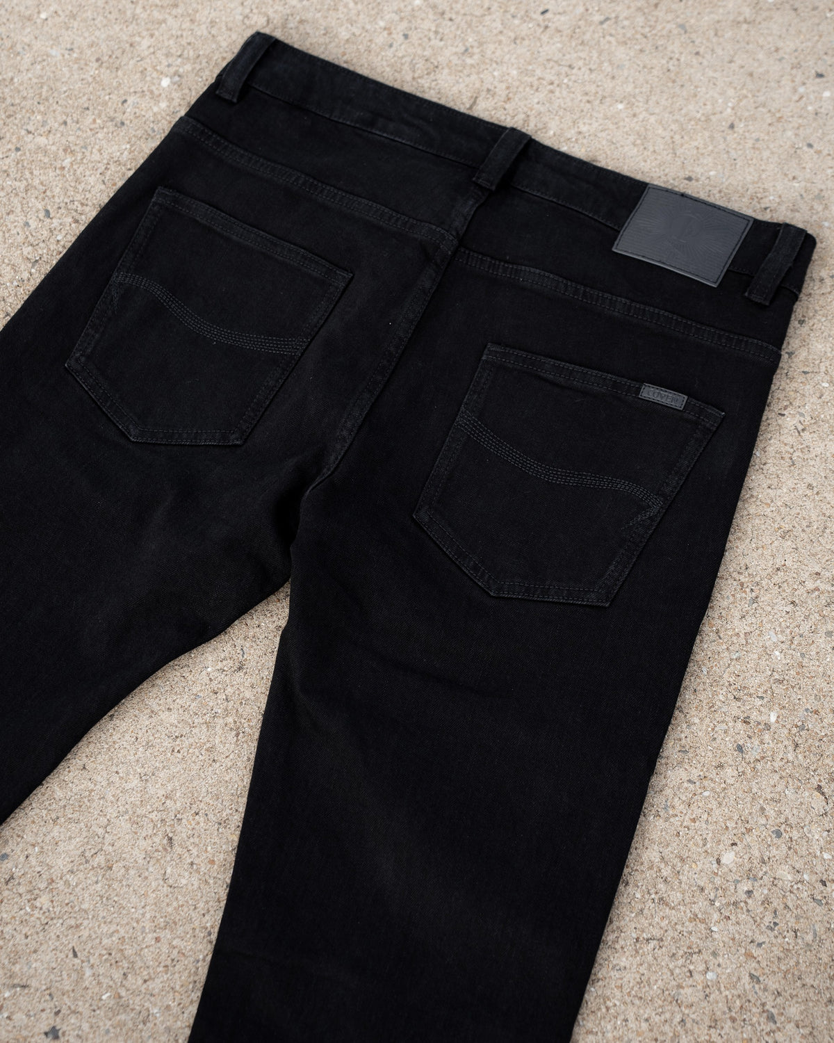 The Wormskin Jeans in Schwarz, Rückansicht der Hüftpartie flach mit beiden Gesäßtaschen und Lederpatch