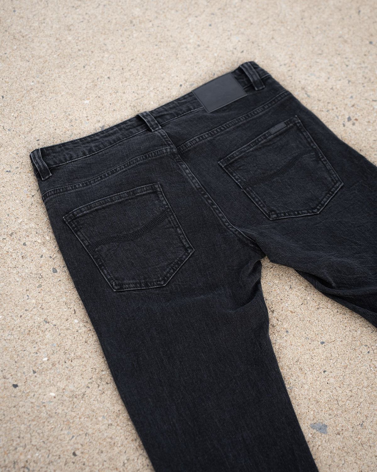 The Wormskin Jeans in Washed Black, Rückansicht flach mit ausgestellten Beinen