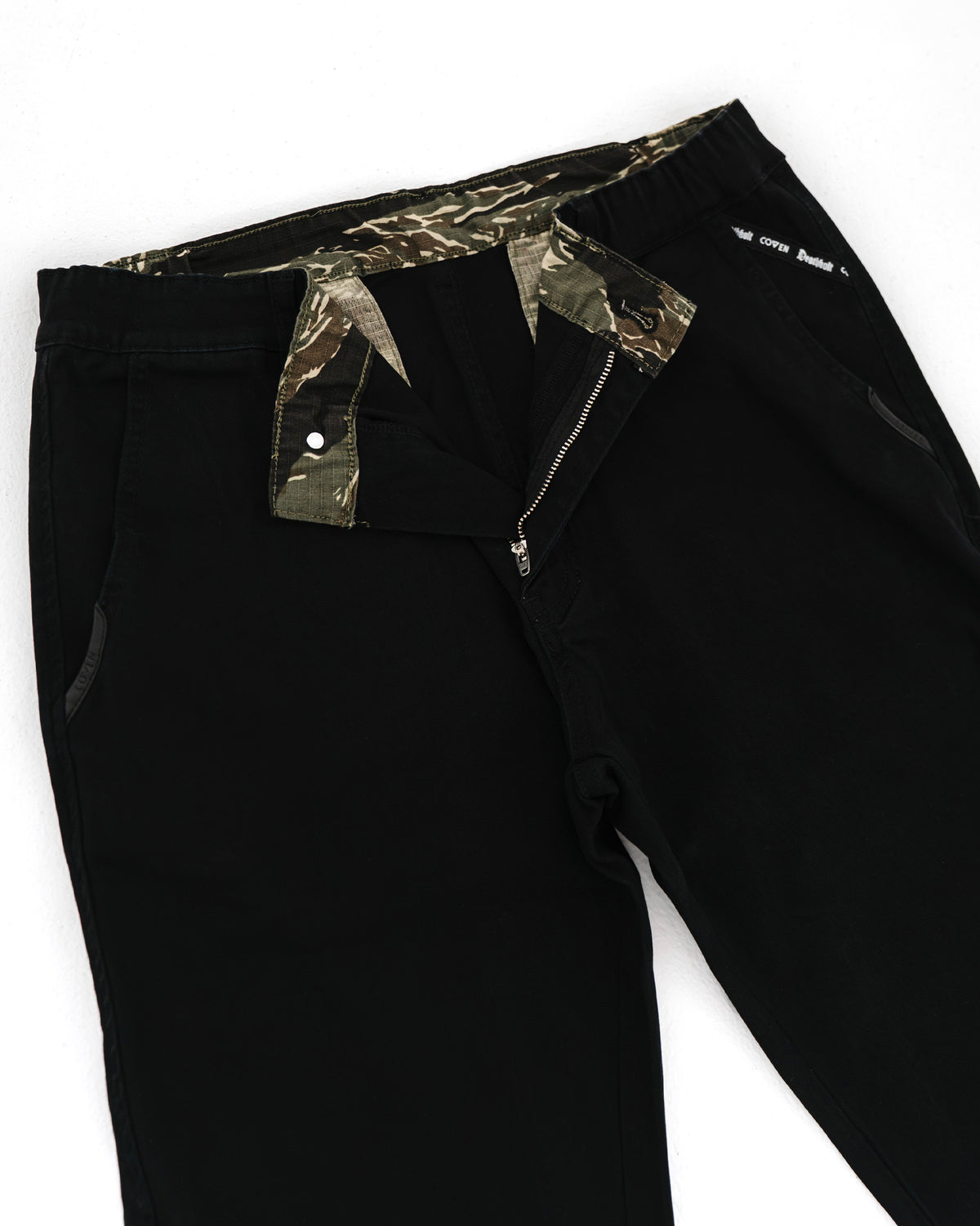 Dead Drop Chino Aeon Tigerstripe in Schwarz, geöffneter Bund mit Tigerstripe-Innenfutter
