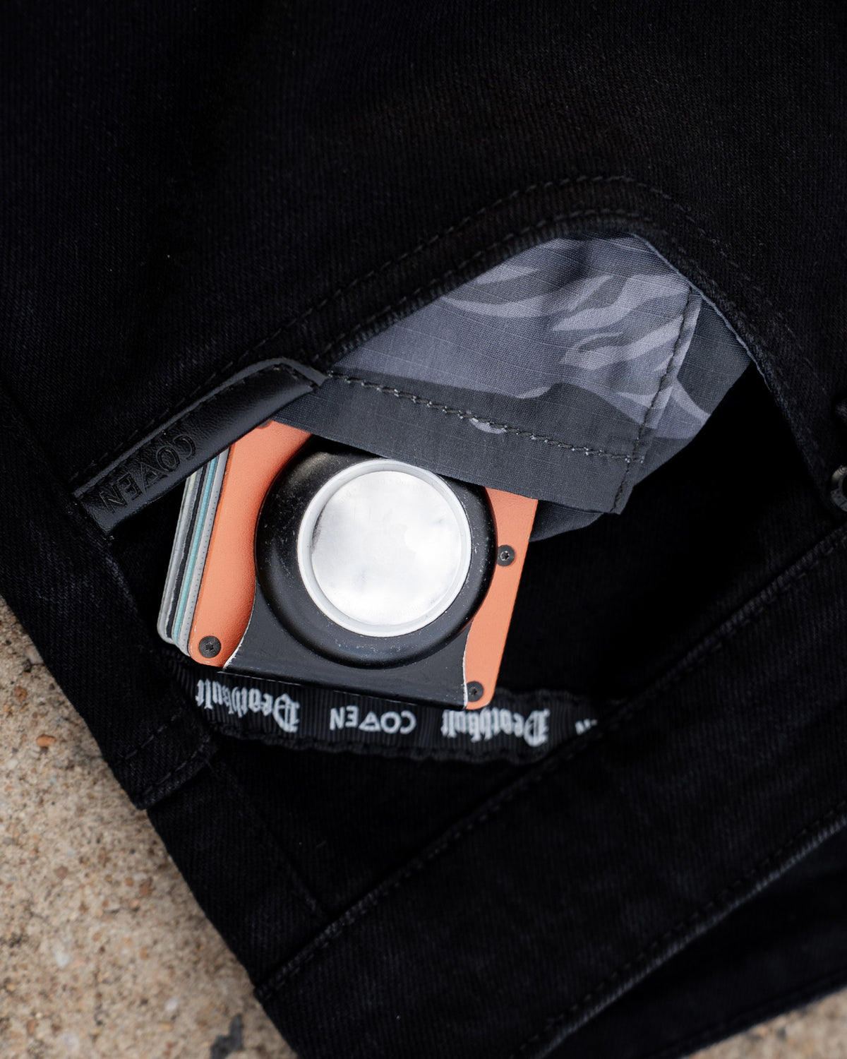 The Wormskin Jeans in Schwarz, Vordertasche geöffnet mit Tiger Stripe Futter und COVEN Wallet