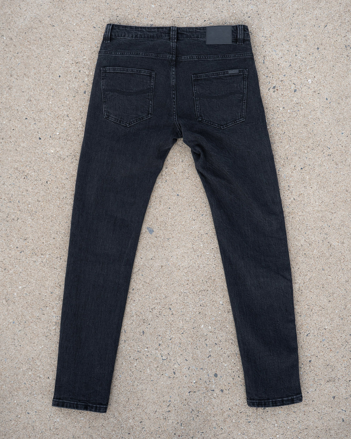 The Wormskin Jeans in Washed Black, komplette Jeans flach von hinten