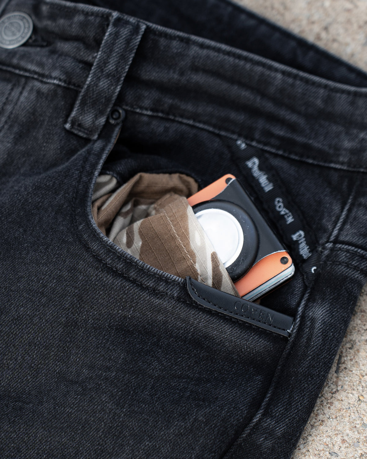 The Wormskin Jeans in Washed Black, Vordertasche mit COVEN Wallet und Tarnfutter