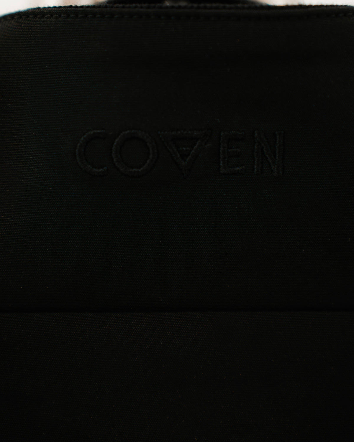 The Pariah Harrington Jacke in Schwarz, dezenter COVEN Logo-Stick Ton in Ton im Nacken