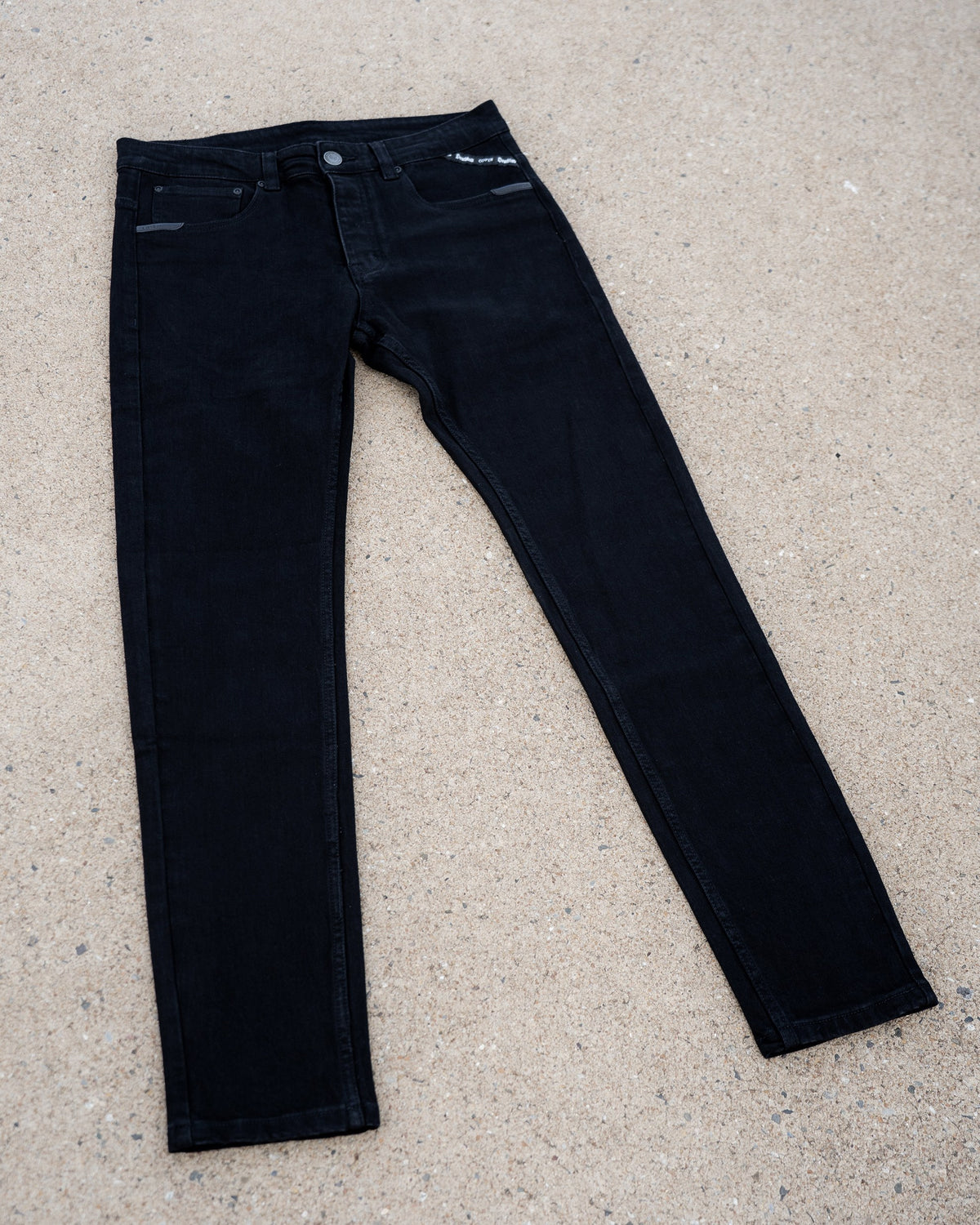 The Wormskin Jeans in Schwarz, komplette Jeans flach von vorn mit ausgestellten Beinen