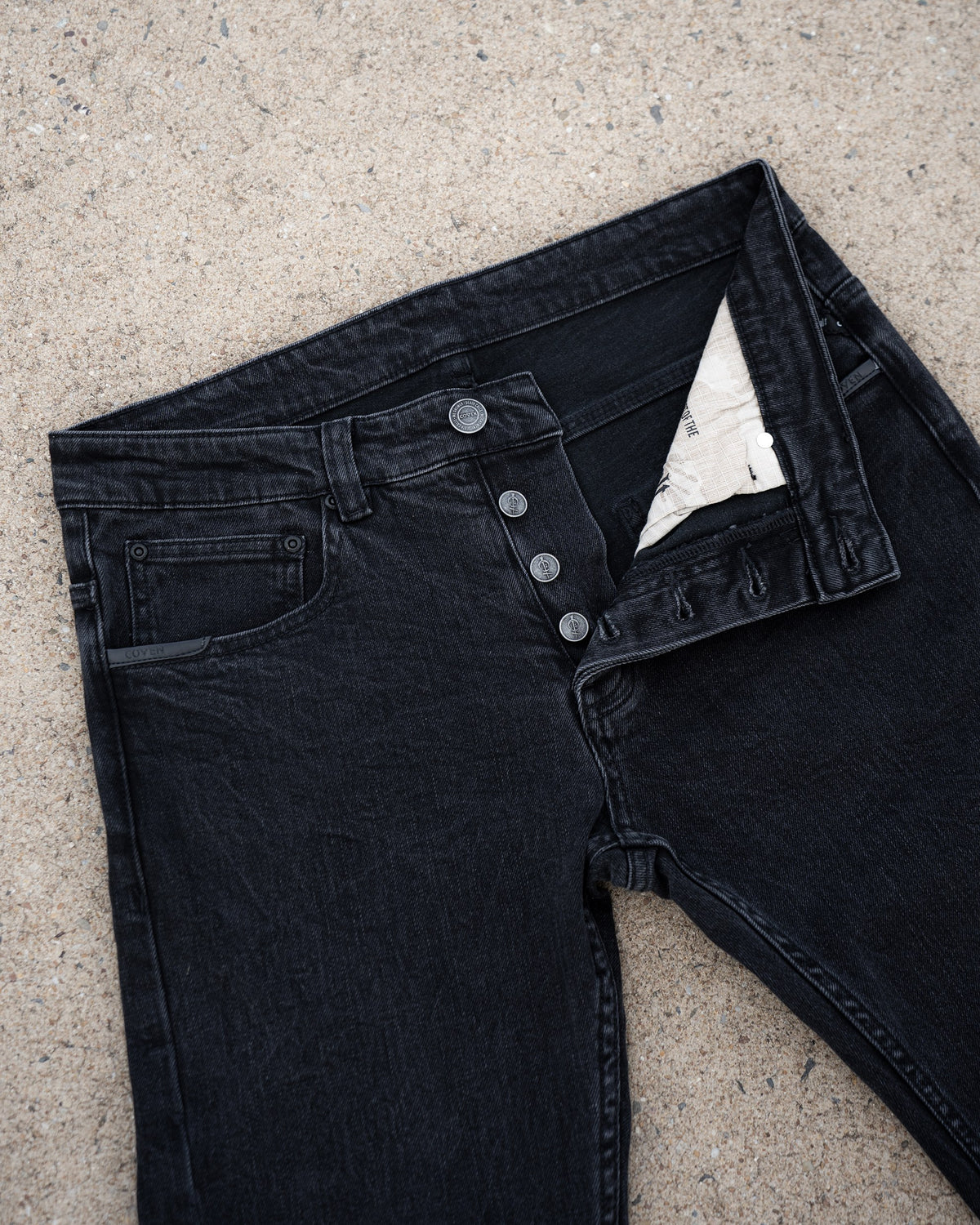 The Wormskin Jeans in Washed Black, Vorderansicht mit geöffneter Knopfleiste