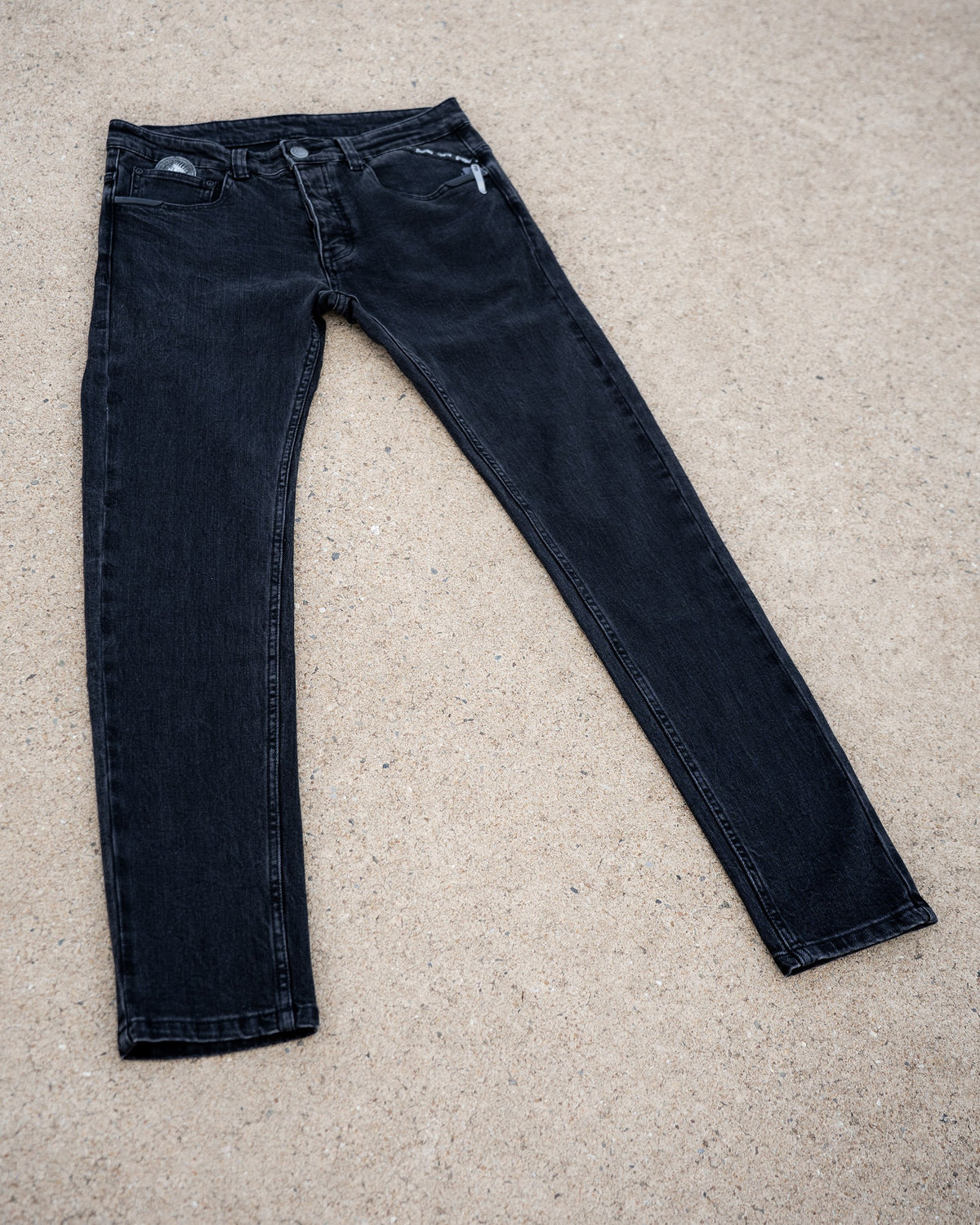 The Wormskin Jeans in Washed Black, komplette Jeans flach von vorn mit ausgestellten Beinen