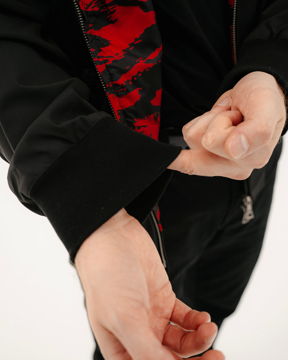 The Pariah Harrington Jacke in Schwarz am Model, Ärmel mit Tiger Stripe Red Futter im Detail